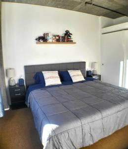 a bedroom with a large bed with blue sheets at City Views & Downtown Bliss in Portland