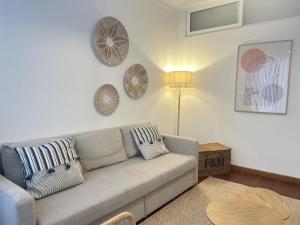 uma sala de estar com um sofá e pratos na parede em 2Room Cozy Apartment Center Caparica em Costa da Caparica