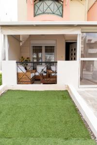 uma casa com uma varanda com relva verde em Unique Modern Apartment em Alexandroúpolis