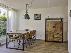 Un comedor con mesa y sillas de madera. en Holiday Home Bellingwolde Comfort by Interhome, en Vlagtwedde