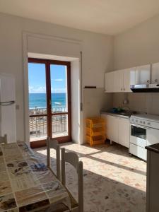 cocina con mesa y vistas al océano en Marger Apartments, en Santa Maria di Castellabate