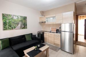 a living room with a couch and a stainless steel refrigerator at Unique Apartment in Alexandroupoli