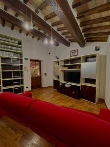 ein Wohnzimmer mit einem roten Sofa und einem TV in der Unterkunft GG Apartments Assisi in Assisi