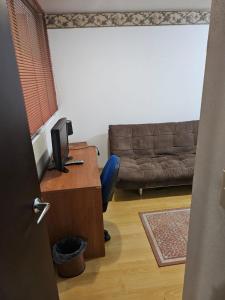 Habitación con escritorio, ordenador y sofá. en Departamento Céntrico CDMX, en Ciudad de México