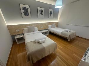 una habitación de hotel con dos camas y una mesa en HOME GV35 By Oktheway, en Sarria
