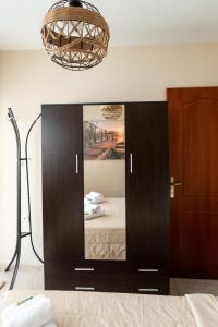 um espelho num quarto com uma cama e um candeeiro em Unique Modern Apartment em Alexandroupoli