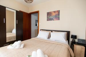 um quarto com uma cama grande e toalhas brancas em Unique Modern Apartment em Alexandroupoli