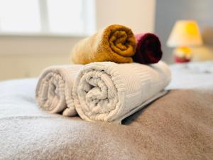 una pila de toallas sentadas encima de una cama en Scandinavian Apartment Hotel- Torsted 1 - 2 room apartment, en Horsens