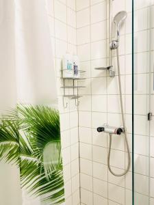 y baño con ducha con cabezal de ducha. en Scandinavian Apartment Hotel- Torsted 1 - 2 room apartment, en Horsens