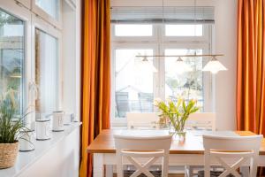a dining room with orange curtains and a table and chairs at Seebadvilla in Timmendorfer Strand