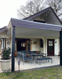 Cette maison dispose d'une terrasse avec un canapé et une table. dans l'établissement Nieuw Beusink, à Winterswijk