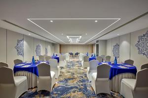 una sala de conferencias con mesas y sillas azules en Holiday Inn Express Bengaluru Bommasandra, an IHG Hotel, en Bangalore
