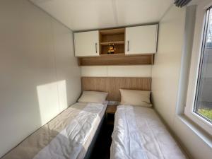 two beds in a small room with a window at Holiday Home Tiny Haus Anellie by Interhome in Riedenburg