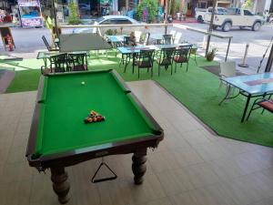 uma mesa de bilhar verde com uma bola em cima em Oasis Hostel & Bar em Praia de Karon