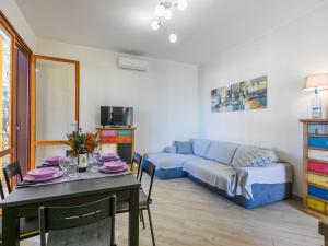 Una sala de estar con una mesa y un sofá azul. en Apartment Sole e mare by Interhome, en San Vincenzo
