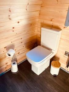 a small bathroom with a toilet in a wooden wall at Hidden Hut - Aros View - Tobermory in Tobermory
