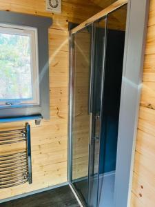 a glass shower in a room with a window at Hidden Hut - Aros View - Tobermory in Tobermory