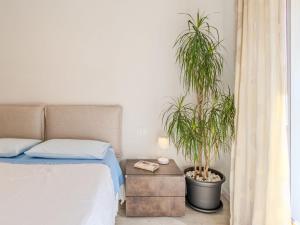 - une chambre avec un lit et deux plantes en pot dans l'établissement Apartment Garden Apartment by Interhome, à Riva del Garda