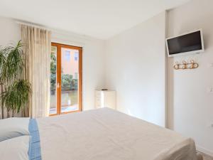 - une chambre blanche avec un lit et une fenêtre dans l'établissement Apartment Garden Apartment by Interhome, à Riva del Garda