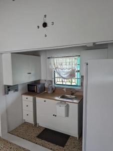 una pequeña cocina con fregadero y ventana en Grand Vue Apartment Vieux Fort, en Vieux Fort
