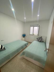 um quarto com 2 camas e uma janela em Nazaré Three Fish na Nazaré