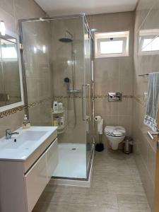 uma casa de banho com um chuveiro, um lavatório e um WC. em Nazaré Three Fish na Nazaré