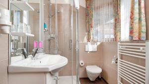 un bagno con lavandino e WC di Erlebnis-Hotel-Appartements a Latschach ober dem Faakersee Altre 32 foto