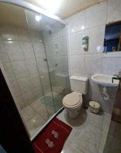 a bathroom with a shower and a toilet and a sink at Pousada paraiso das conchas hostel in Cabo Frio