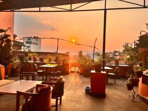 ein Restaurant mit Tischen und Stühlen und einem Sonnenuntergang in der Unterkunft Trekkers Home in Kathmandu