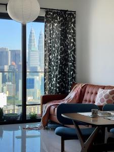 a living room with a couch and a large window at Rooms with KLCC and KL Tower view by Yee in Kuala Lumpur