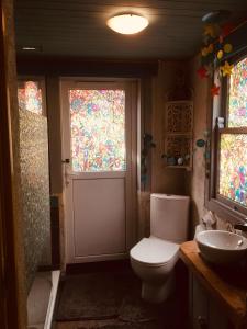 uma casa de banho com um WC, um lavatório e uma janela em Cosy Shepherds hut Between Maple and Hawthorn em Mountshannon