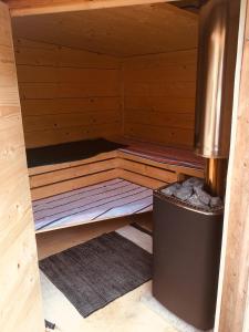 uma pequena sauna de madeira com um caixote do lixo em Cosy Shepherds hut Between Maple and Hawthorn em Mountshannon