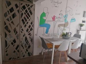 a dining room with a wall mural of a couple sitting at a table at Sweet Sweet Home in Tolve