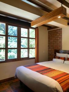 1 dormitorio con 1 cama grande y ventanas en Panorama B&B, en Machu Picchu