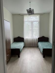 two beds in a room with a window at Rcheuli Villa in Charnali in Batumi
