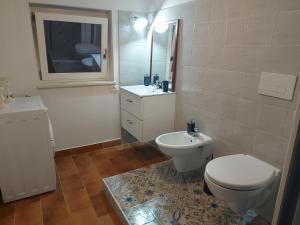 a white bathroom with a toilet and a sink at Casa Vacanza Fiori di Maggio in Pulsano +21 photos