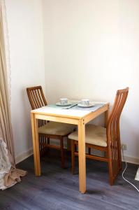 einen Holztisch mit zwei Stühlen und einem Tisch mit einem Tisch und einem Stuhl in der Unterkunft Handy Studio near Nato in Brüssel