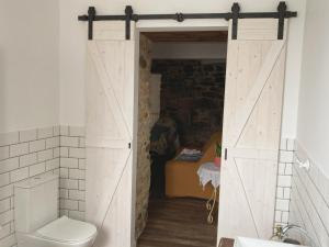 Baño con puerta corredera de granero con aseo en Apartamento en Casa Oliveros, Razo, en A Coruña