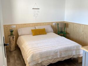 Dormitorio con cama con almohada amarilla en Apartamento en Casa Oliveros, Razo, en A Coruña