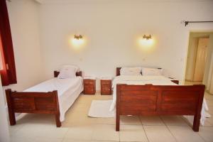 een slaapkamer met 2 bedden en 2 nachtkastjes bij Sara Chambre d'hôtes in Antananarivo