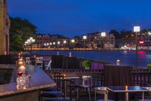 a restaurant with tables and chairs on a balcony at night at Pier 5 Hotel Baltimore in Baltimore