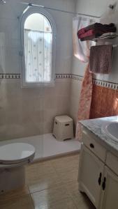 łazienka z toaletą, umywalką i oknem w obiekcie Chez Vida Vera Playa nudista w mieście Playas de Vera