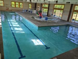 a swimming pool with blue chairs in a building at The "Okemo House" at Trailside in Ludlow