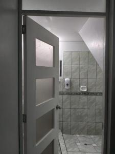 een badkamer met een douche en een glazen deur bij Departamento de 3 pisos a 9 cuadras de la plaza in Ayacucho