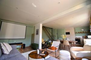 a living room with a couch and a screen at Charme Parisien : Sauna & Jardin in Aubervilliers