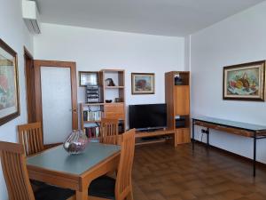 ein Wohnzimmer mit einem Tisch und einem TV in der Unterkunft King 35 in Bologna