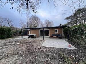4 tot 8 persoons huisje - Veluwemeer - Biddinghuizen - Harderwijk - Elburg في بيدينغويزين: منزل صغير مع فناء في ساحة