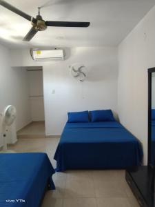1 dormitorio con 1 cama azul y ventilador de techo en Apartamento Erika 301 en el centro de Santa Marta, en Santa Marta