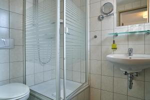a bathroom with a shower and a toilet and a sink at Hotel Römer by Fairway Hotels in Günzburg +52 photos