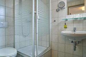 a bathroom with a shower and a toilet and a sink at Hotel Römer in Günzburg